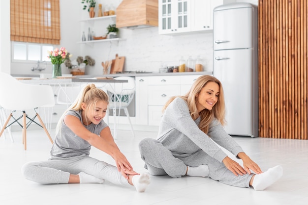 Madre e hija haciendo ejercicios de estiramiento