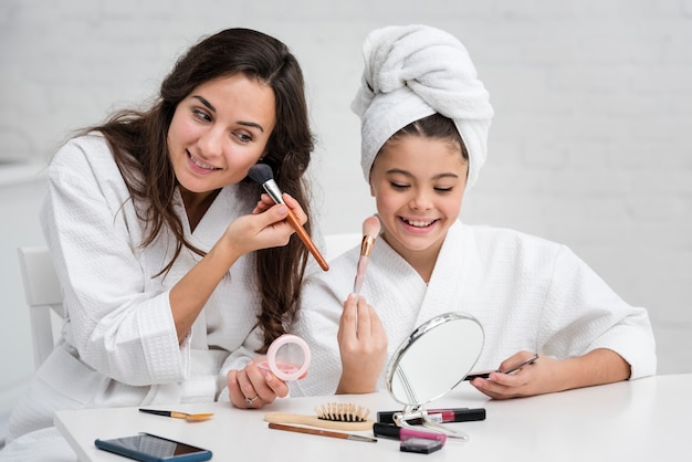 Madre e hija haciendo su maquillaje