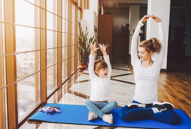 Madre e hija haciendo yoga