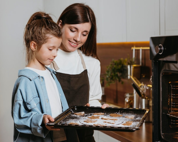 Madre e hija horneando galletas juntas en casa