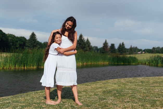 Madre e hija huggin por el lago