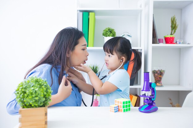 Madre e hija jugando al doctor con estetoscopio