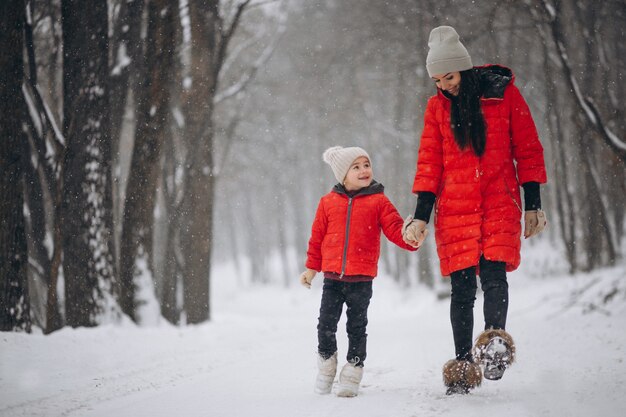 Madre e hija jugando en el parque de invierno