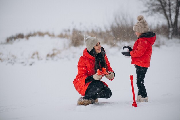 Madre e hija jugando en el parque de invierno