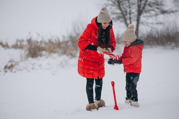 Madre e hija jugando en el parque de invierno