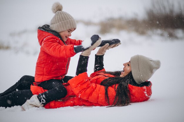 Madre e hija jugando en el parque de invierno