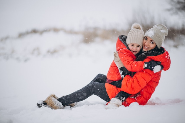 Madre e hija jugando en el parque de invierno