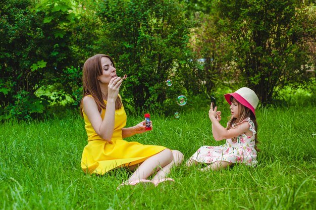 Madre e hija jugando con pompas de jabón