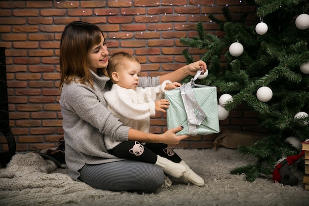 Madre e hija junto al árbol de Navidad