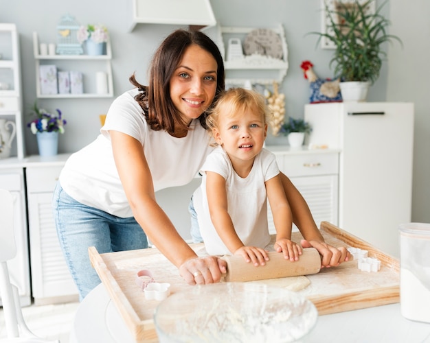 Foto gratuita madre e hija linda con rodillo de cocina