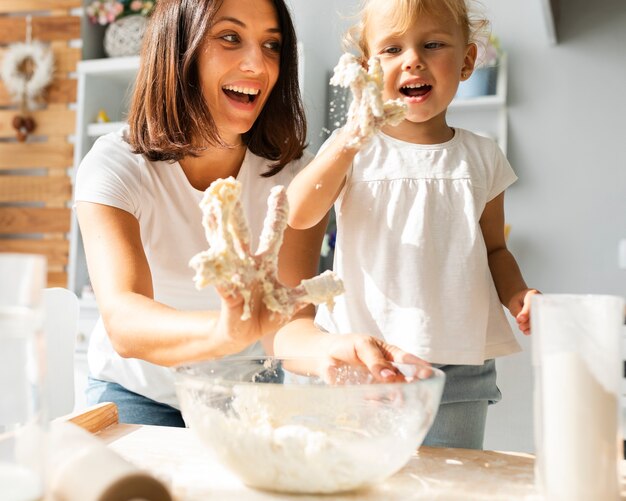 Madre e hija con las manos llenas de masa