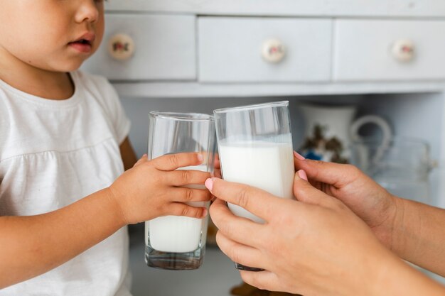Madre e hija manos sosteniendo gases de leche