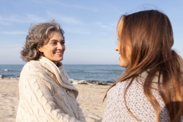 Madre e hija, manos de valor en cartera, juntos, en la playa