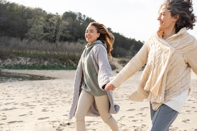 Madre e hija, manos de valor en cartera, juntos, en la playa