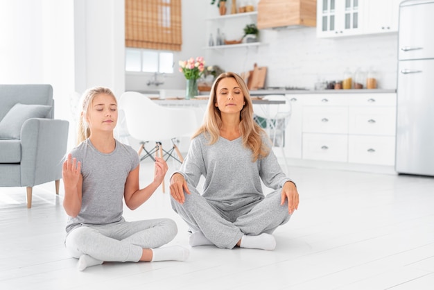 Foto gratuita madre e hija meditando en interiores