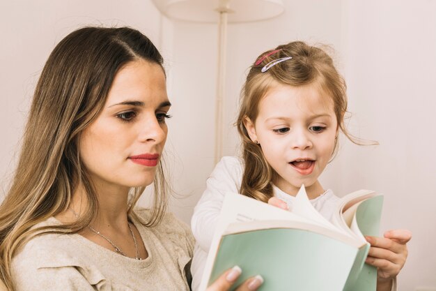 Madre e hija moviendo las páginas del libro