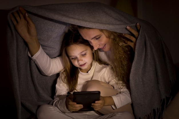 Foto gratuita madre e hija pasan tiempo juntas detrás de una manta