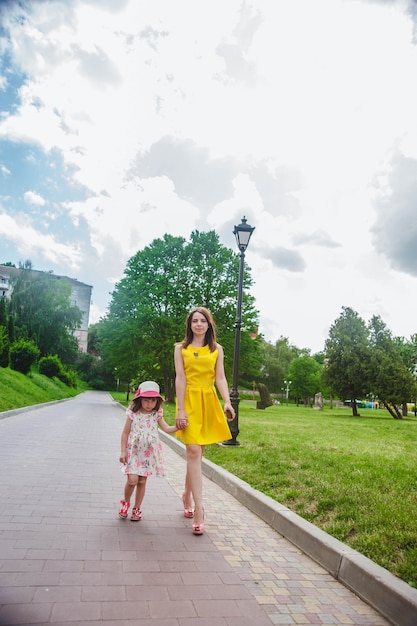 Madre e hija paseando por un camino con adoquines