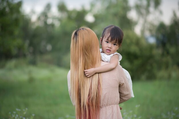 Madre e hija pequeña jugando juntos en un parque