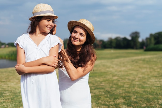 Madre e hija posando al aire libre medio tiro