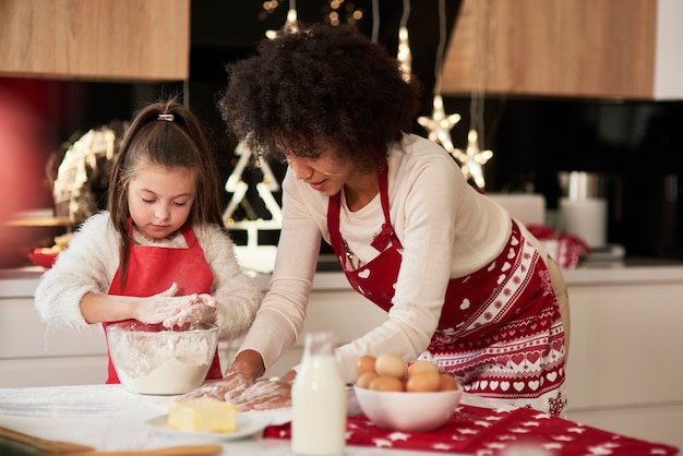 Madre e hija preparando bocadillos en la cocina