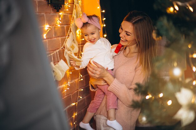 Madre e hija que decoran el hogar en Navidad