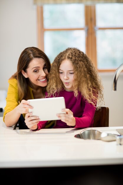 Madre e hija que usa la tableta digital