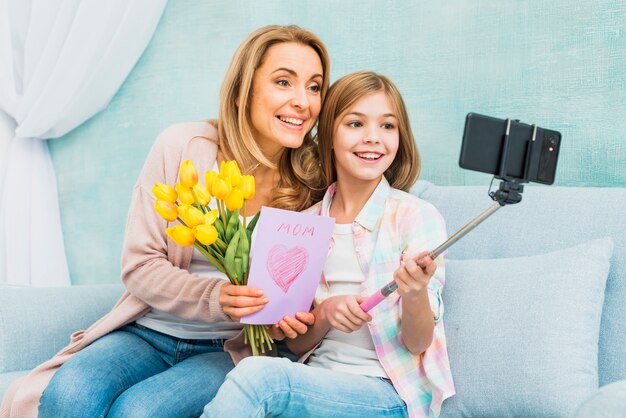 Madre e hija con regalos tomando selfie