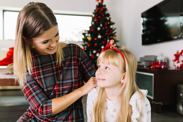 Madre e hija en salón con decoración de navidad