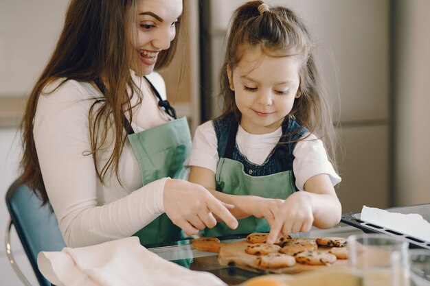 Madre e hija sentada en una cocina con galletas