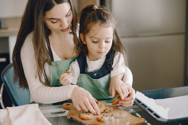 Madre e hija sentada en una cocina con galletas