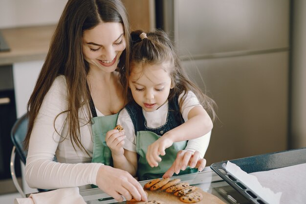 Madre e hija sentada en una cocina con galletas