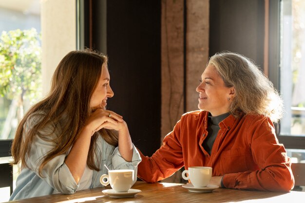 Madre e hija sonrientes de tiro medio