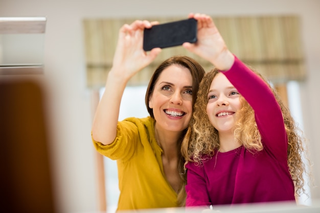 Madre e hija teniendo autofoto desde el teléfono móvil