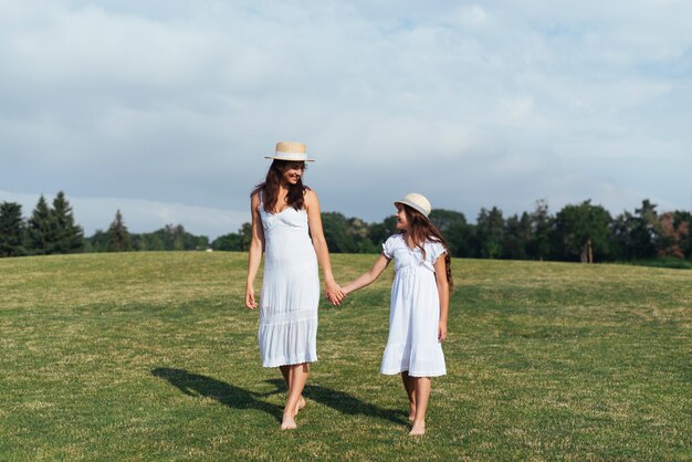 Madre e hija tomados de las manos al aire libre