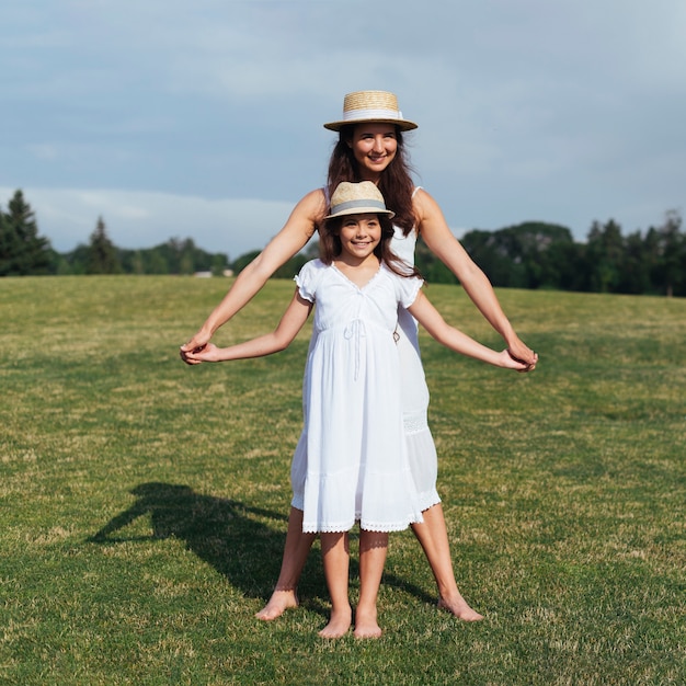 Madre e hija tomados de las manos al aire libre