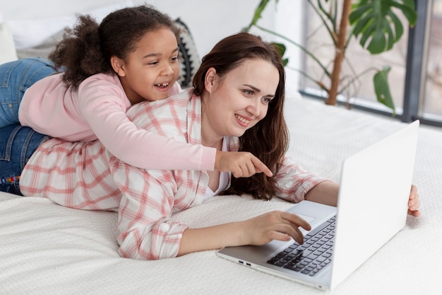 Madre e hija usando la computadora portátil juntas