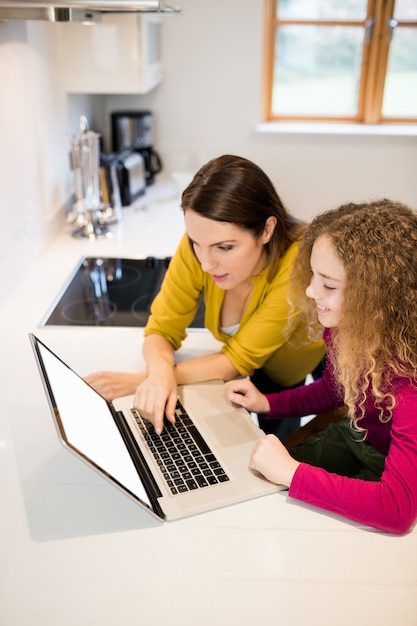 Madre e hija usando la computadora portátil