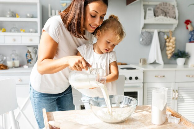 Madre e hija vertiendo leche en un tazón