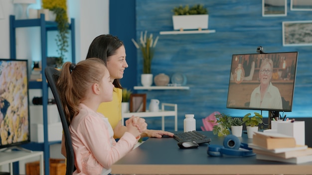 Foto gratuita madre e hija mediante videollamada para charlar con la abuela