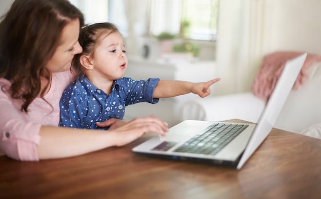 Madre e hija viendo videos en una computadora portátil