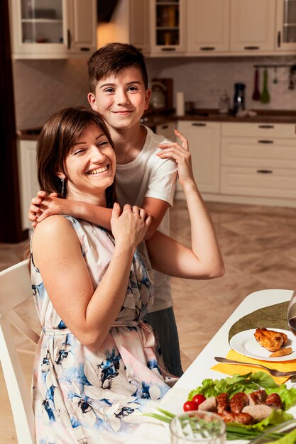 Madre e hijo abrazados en la mesa