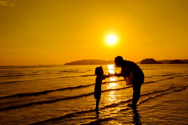 Una madre e hijo en al aire libre al atardecer con espacio de copia