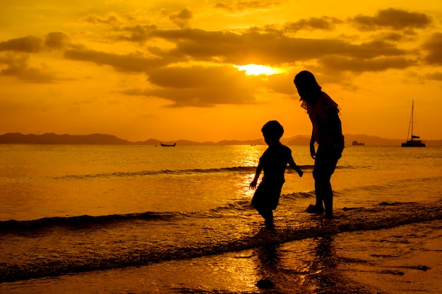 Una madre e hijo en al aire libre al atardecer con espacio de copia