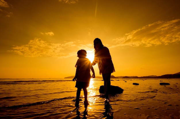 Una madre e hijo en al aire libre al atardecer con espacio de copia