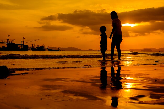 Una madre e hijo en al aire libre al atardecer con espacio de copia