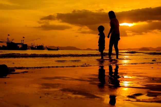 Una madre e hijo en al aire libre al atardecer con espacio de copia