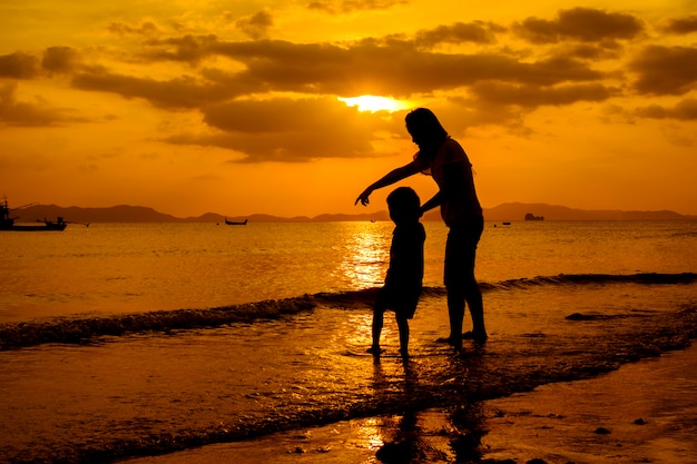 Una madre e hijo en al aire libre al atardecer con espacio de copia