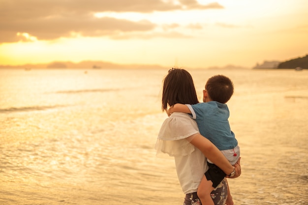 Una madre e hijo en al aire libre al atardecer con espacio de copia