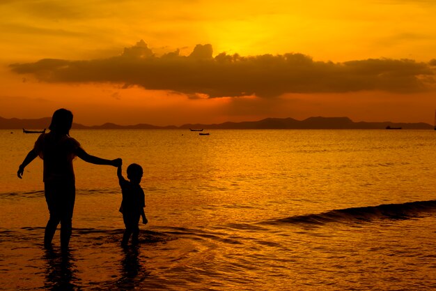 Una madre e hijo en al aire libre al atardecer con espacio de copia